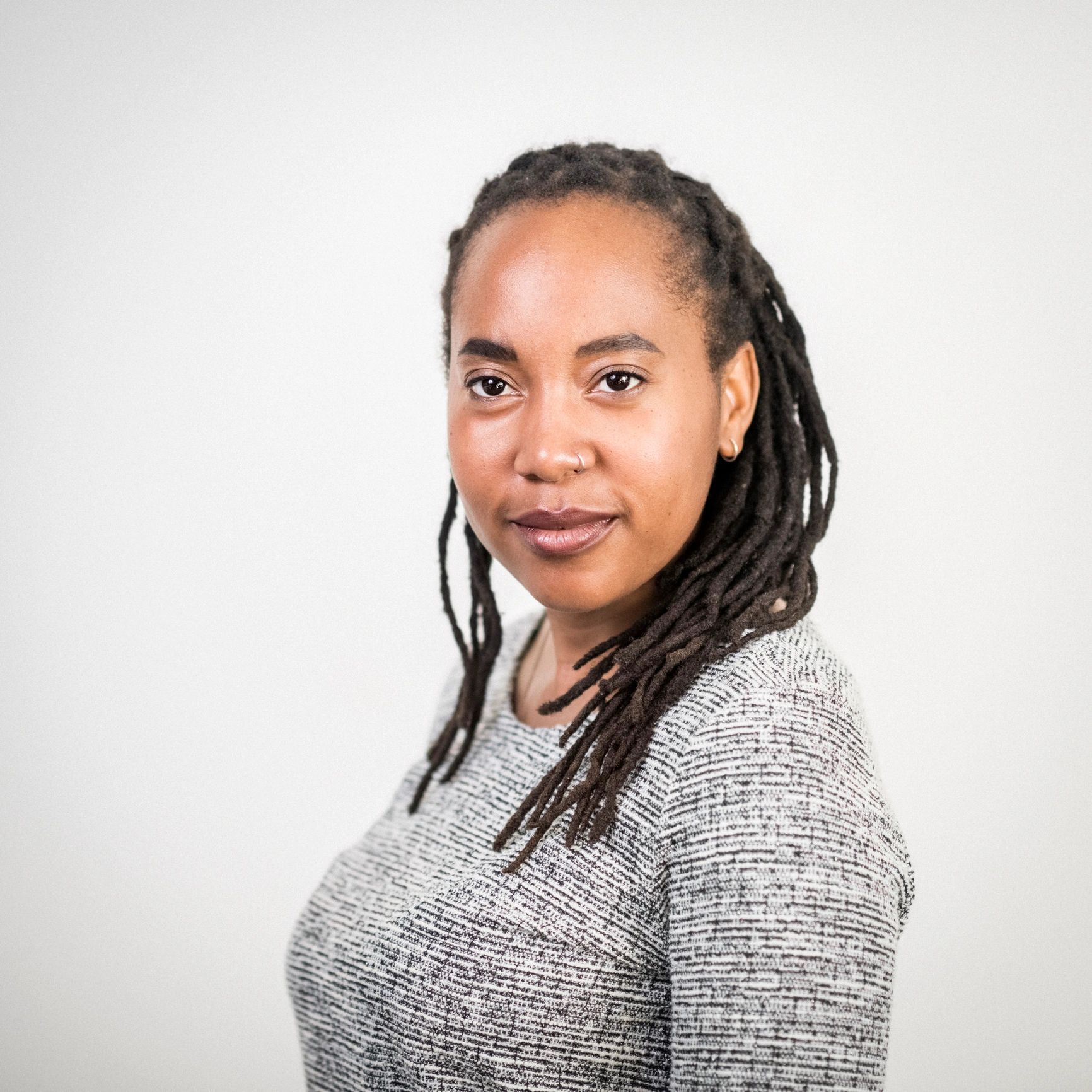 Headshot of a confident woman with dreadlocks