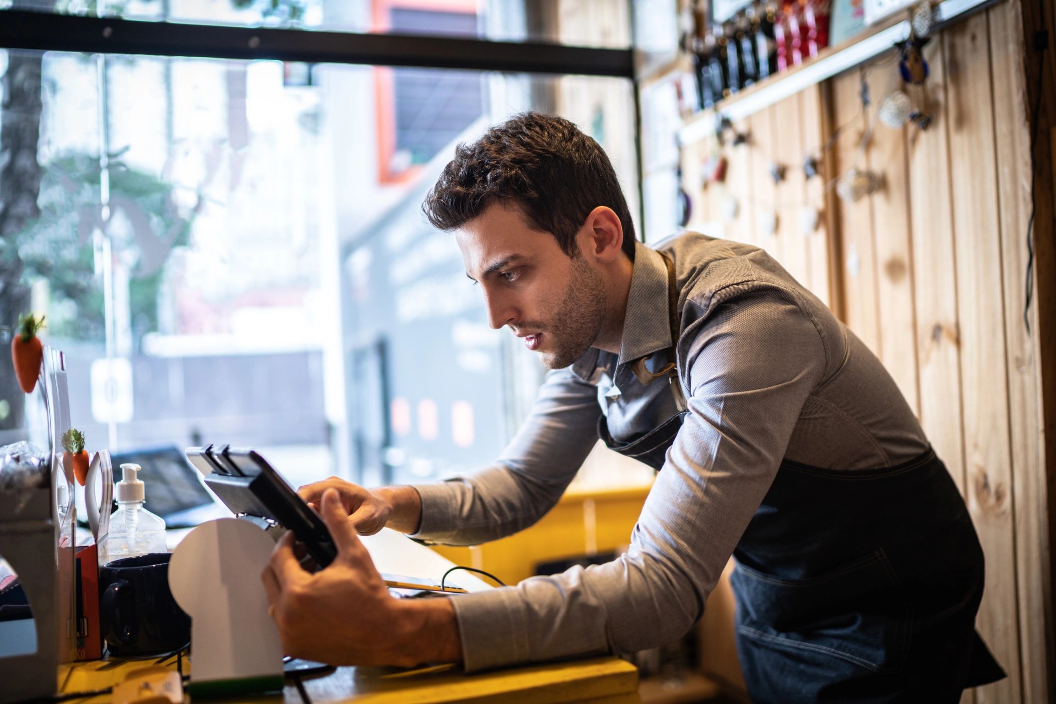 Small business owner using a tablet at a store counter