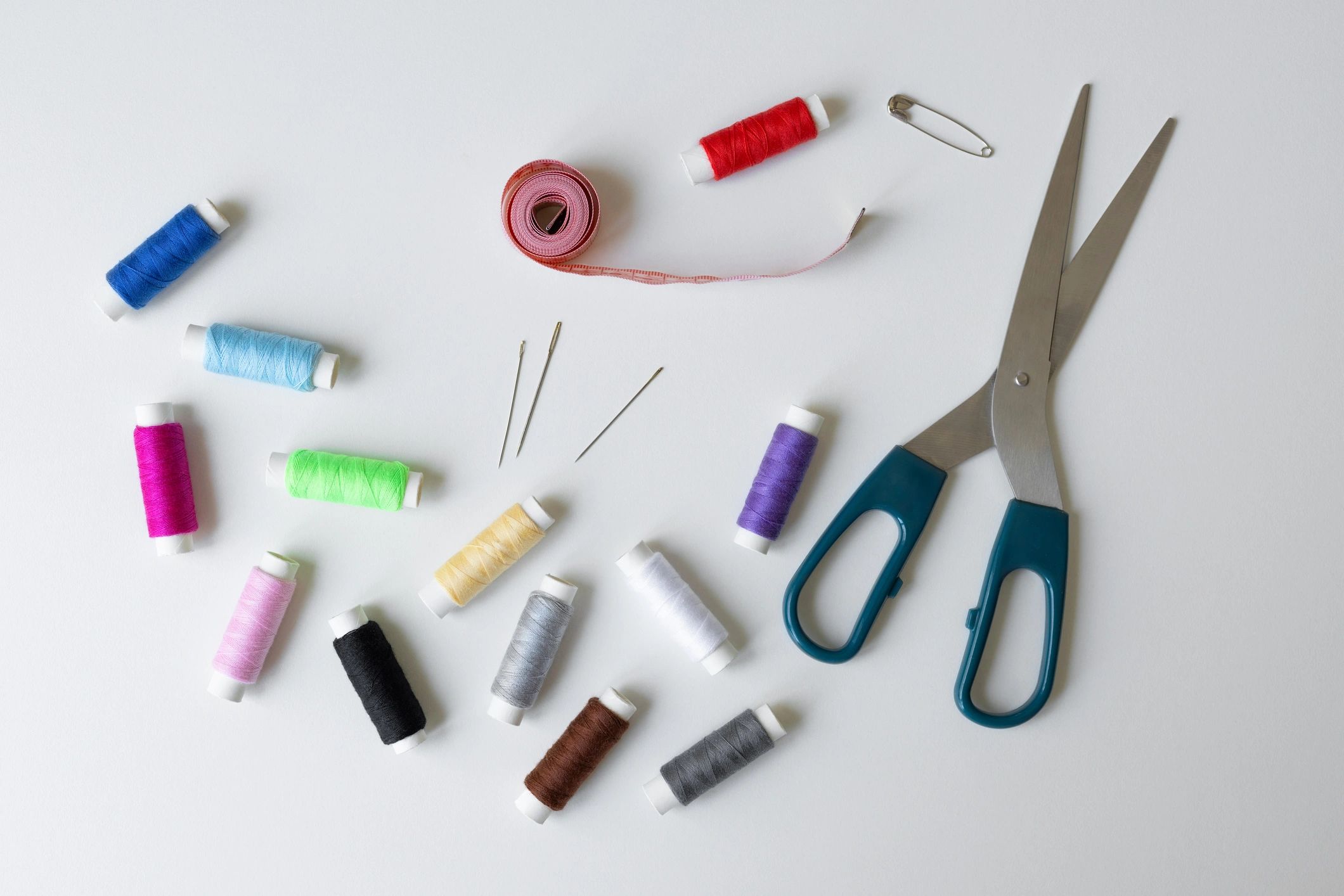 Sewing tools and colorful threads laid out on a work surface